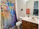 Bright bathroom featuring colorful shower curtain, neutral countertop and a built in vanity at 11521 Coastal Dr, Indianapolis, IN 46229