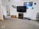 Open-concept living room with large TV, electric fireplace, and neutral carpet at 11521 Coastal Dr, Indianapolis, IN 46229
