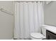 The toilet, shower with simple, white curtain, and the wall details in this bathroom create a clean and modern space at 1299 Timber Bluff Rd, Westfield, IN 46074