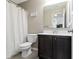 Cozy bathroom with a dark vanity, marble countertop, updated fixtures, and a shower with a white shower curtain at 1299 Timber Bluff Rd, Westfield, IN 46074