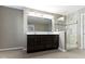Bathroom featuring a double sink vanity, a large mirror, and a tiled glass shower at 1299 Timber Bluff Rd, Westfield, IN 46074