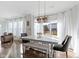 Bright dining room with a modern light fixture, table with chairs and a bench, and natural light at 1299 Timber Bluff Rd, Westfield, IN 46074