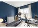 Bright exercise room with a treadmill, desk, and ample natural light from a large window with white curtains at 1299 Timber Bluff Rd, Westfield, IN 46074