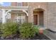 Welcoming covered front porch entrance featuring a brick archway and lush landscaping at 1299 Timber Bluff Rd, Westfield, IN 46074
