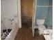 Dilapidated bathroom includes a damaged bathtub, toilet, and sink at 1310 E 5Th St, Muncie, IN 47302