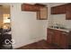 Dilapidated kitchen features aging cabinets, double basin sink and damaged flooring at 1310 E 5Th St, Muncie, IN 47302