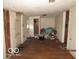 This is a dilapidated living room featuring wood paneling and damaged flooring at 1310 E 5Th St, Muncie, IN 47302