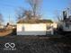 A small white shed with a simple door, located in the backyard of the property at 1310 E 5Th St, Muncie, IN 47302