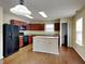 Modern kitchen featuring dark wood cabinets, an island, and black appliances at 14457 Orange Blossom Trl, Fishers, IN 46038
