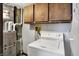 Bright laundry area with washer, wood cabinets and adjacent mechanicals at 1529 Bailey Dr, Indianapolis, IN 46241