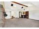 Open living room with a beamed ceiling, carpeted floors, and a door that opens to a bathroom at 1529 Bailey Dr, Indianapolis, IN 46241
