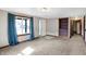 Bright living room with neutral carpet, built-in shelving, and a large window with blue drapes at 1529 Bailey Dr, Indianapolis, IN 46241