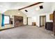 Open-plan living room with beamed ceiling, brick fireplace, and carpeted floors at 1529 Bailey Dr, Indianapolis, IN 46241