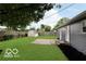 Backyard with green lawn, wooden fence, and gray exterior elevation at 1807 Dayton Ave, Indianapolis, IN 46203