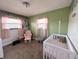 Bedroom featuring light green walls and a white crib and rocking chair at 1807 Dayton Ave, Indianapolis, IN 46203