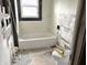 Bathroom with a white tub, a window with black trim, and evidence of tile work in progress at 1826 Mansfield St, Indianapolis, IN 46202