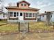 A cozy bungalow-style home with mixed brick and vinyl siding, visible house number, and a small fenced front yard at 1826 Mansfield St, Indianapolis, IN 46202