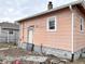 View of the rear exterior of the house with peach siding and visible damage at 1826 Mansfield St, Indianapolis, IN 46202