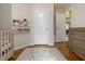 Inviting Bedroom with a crib, book display, hardwood floors, and changing table at 23 Greenacre Dr, Brownsburg, IN 46112