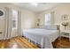 Bright bedroom with hardwood floors, a ceiling fan, two windows, and a comfortable queen-sized bed at 23 Greenacre Dr, Brownsburg, IN 46112