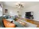Bright living room with hardwood floors, a green sofa, and a modern entertainment center at 23 Greenacre Dr, Brownsburg, IN 46112