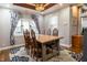Inviting dining room showcasing a wood table with six chairs and a window adorned with blue and white curtains at 3615 E State Rd 32, Lebanon, IN 46052