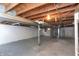 Unfinished basement features exposed wood ceiling, concrete floor, and white painted block walls at 3723 N Olney St, Indianapolis, IN 46218