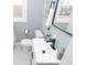A bathroom with light gray walls, white trim, a toilet, a sink, and a mirror at 3723 N Olney St, Indianapolis, IN 46218