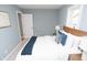 This bedroom features light gray walls, white trim, and a queen bed with a navy blue throw blanket at 3723 N Olney St, Indianapolis, IN 46218