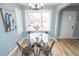 Bright dining room featuring a glass table, modern chandelier, and a large window with natural light at 3723 N Olney St, Indianapolis, IN 46218