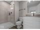Bright bathroom featuring tiled shower, toilet, and vanity with white cabinetry at 4160 Douro Trl, Westfield, IN 46062