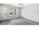Bedroom with plush gray carpeting, a ceiling fan, and a door to a balcony overlooking the yard at 4242 Winthrop Ave, Indianapolis, IN 46205