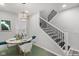 Bright dining area with staircase, a contemporary light fixture, and stylish furniture at 4242 Winthrop Ave, Indianapolis, IN 46205