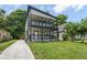 Charming two-story home featuring a spacious double-decker porch with stylish black railings and a well-maintained lawn at 4242 Winthrop Ave, Indianapolis, IN 46205