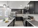 Modern kitchen featuring stainless steel appliances, black cabinets, marble countertops, and stylish backsplash at 4242 Winthrop Ave, Indianapolis, IN 46205