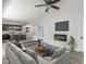 Cozy living room featuring a modern fireplace, ceiling fan, neutral walls, and a comfortable gray sofa at 4242 Winthrop Ave, Indianapolis, IN 46205