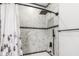 Close-up of luxurious shower with marble tiling, a rainfall shower head, and modern fixtures at 4242 Winthrop Ave, Indianapolis, IN 46205