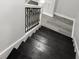 Elegant staircase with black wood treads and decorative wrought iron railing leading to the upper level at 4242 Winthrop Ave, Indianapolis, IN 46205