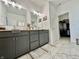 Elegant bathroom with dual sinks, marble floors, gray cabinets, and a walk-in closet at 50 Hovden Dr, Cicero, IN 46034
