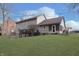 View of the back exterior of the house, with deck, screened in porch and level yard at 504 Stony Creek Cir, Noblesville, IN 46060