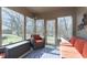 Cozy sunroom with lots of natural light, wicker furniture, and views of the wooded backyard at 504 Stony Creek Cir, Noblesville, IN 46060