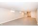 Spacious open basement with grey floor and stairs to the main level with a window at 520 N Parker Ave, Indianapolis, IN 46201