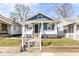 Charming blue home featuring a covered porch, landscaped yard, and inviting curb appeal at 520 N Parker Ave, Indianapolis, IN 46201