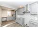 Kitchen with gray cabinets, subway backsplash, granite counters, wood look ceramic tile, and stainless range hood at 520 N Parker Ave, Indianapolis, IN 46201