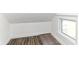 Attic room with wood-look floors, a window, and white walls and ceiling at 59 E Troy Ave, Indianapolis, IN 46225