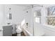 This bathroom features natural light, a tub, a toilet, and a sink with a gray cabinet at 59 E Troy Ave, Indianapolis, IN 46225