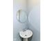 Small pedestal sink with round mirror in a bathroom at 59 E Troy Ave, Indianapolis, IN 46225