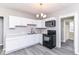 Modern kitchen featuring white cabinets, updated appliances, and sleek gray floors at 59 E Troy Ave, Indianapolis, IN 46225