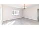 Bright, open living room with gray floors, chandelier lighting, and a large window at 59 E Troy Ave, Indianapolis, IN 46225