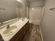 Full bathroom features double sinks, vanity, shower, and tile flooring at 6114 Arrowhead Dr, Anderson, IN 46013